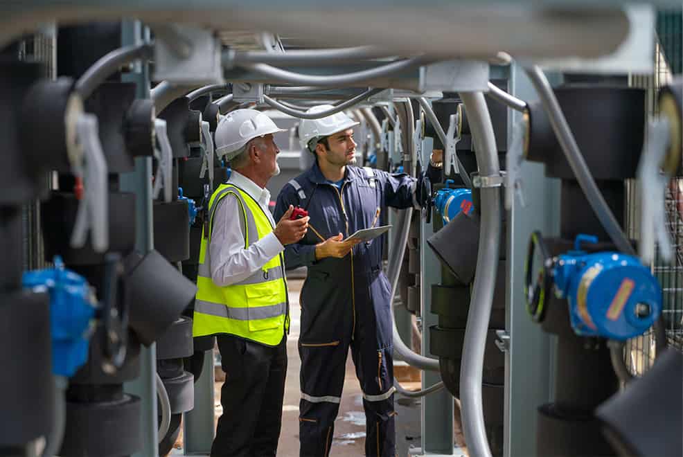 two male engineers working in energy efficiency maintenance strategies in a factory